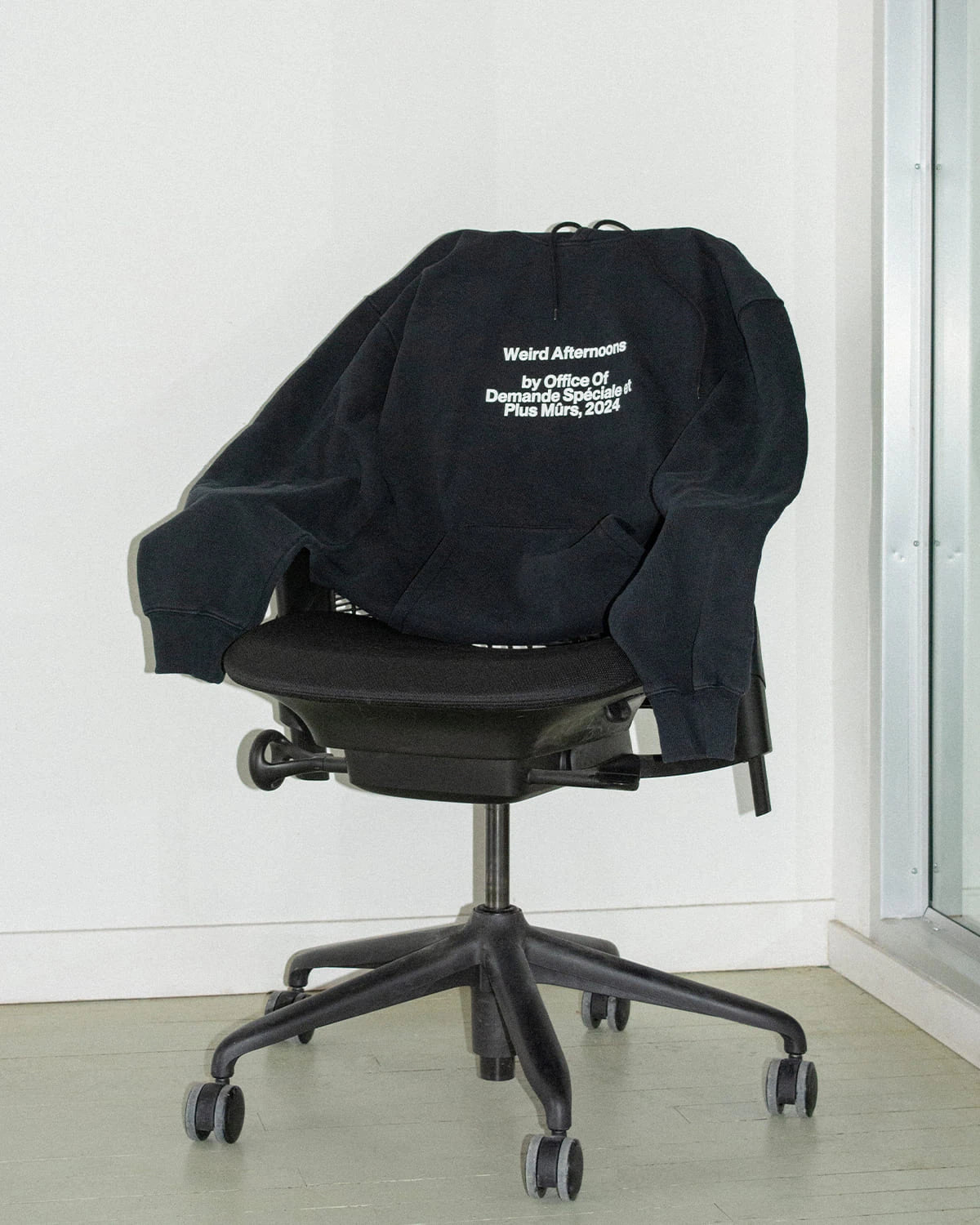 Chandail noir OODS PM « Weird Afternoons » drapé sur une chaise de bureau (OODS PM — Weird Afternoons)