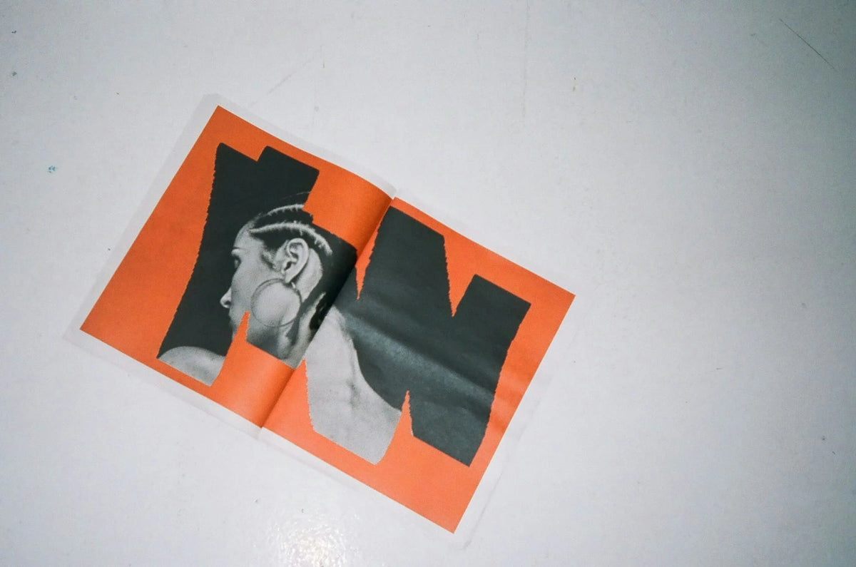 Then-Now — feuillet orange avec portrait de profil en noir et blanc et lettrage « N N »