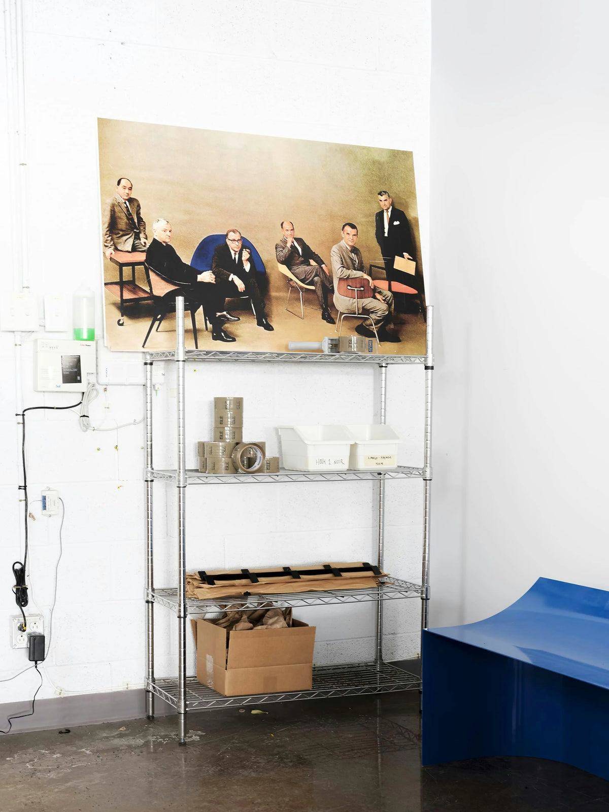 ISLE — grande affiche photo encadrée posée près d'une étagère métallique en atelier