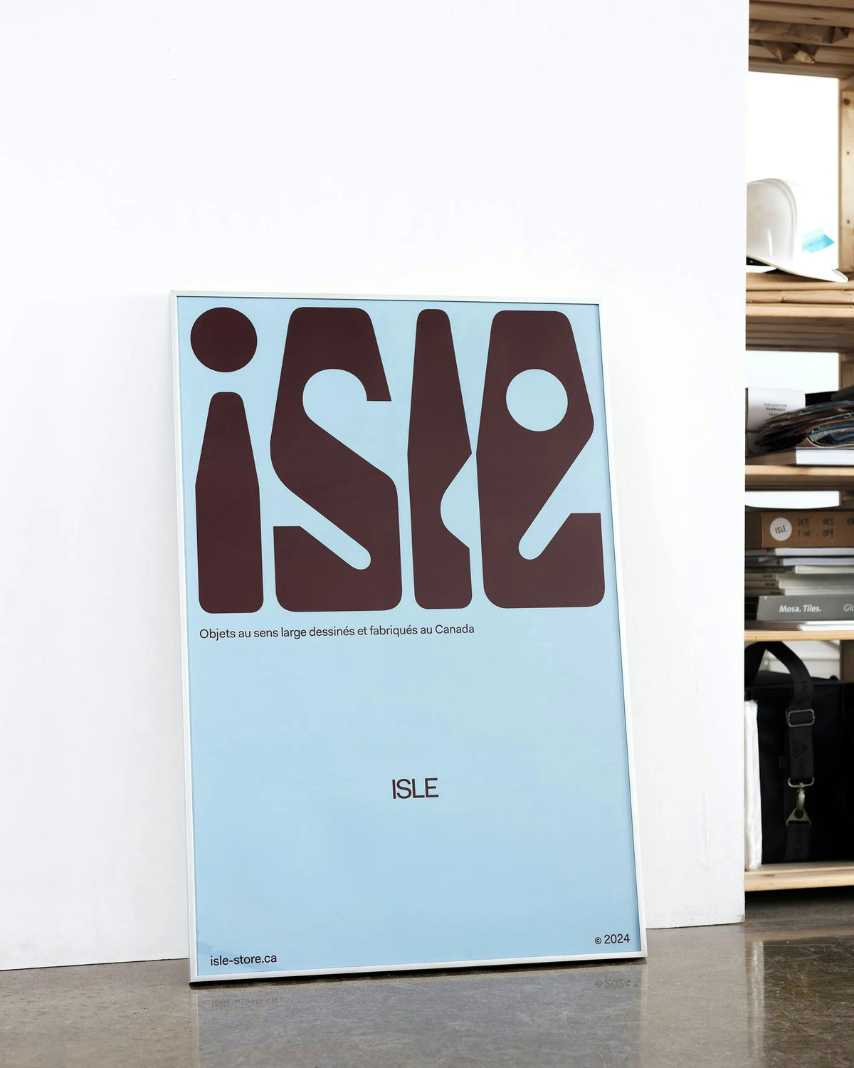 ISLE — affiche bleue avec wordmark organique brun et mention « Objets au sens large dessinés et fabriqués au Canada »