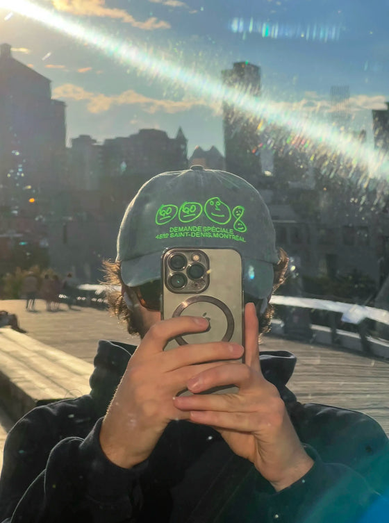 Personne portant la casquette bleu-verte Demande Spéciale, photo prise dans un miroir