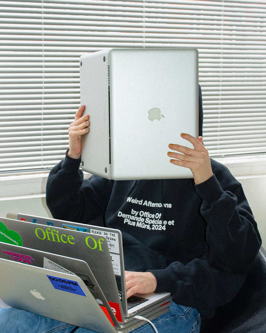 Personne tenant un MacBook devant le visage, lancement « Weird Afternoons »