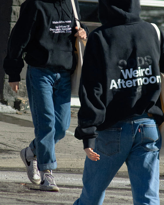Deux personnes de dos portant le chandail « Weird Afternoons » dans la rue