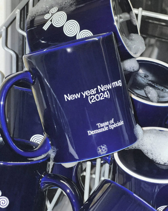 Tasse bleu marine OODS en gros plan, « New year New mug (2024) », dans la mousse