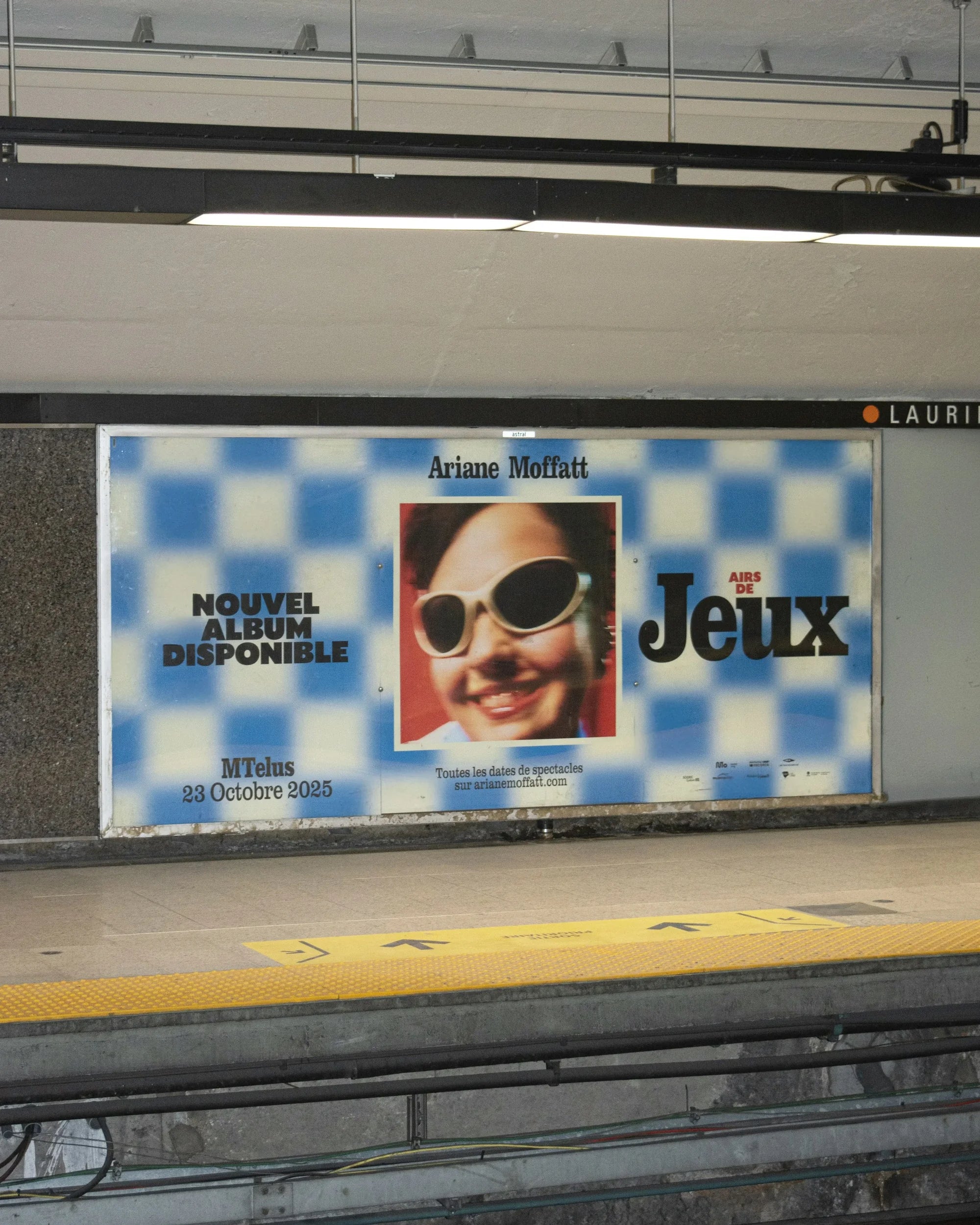 Airs de Jeux — affichage publicitaire en station de métro, motif damier bleu « Nouvel album disponible »