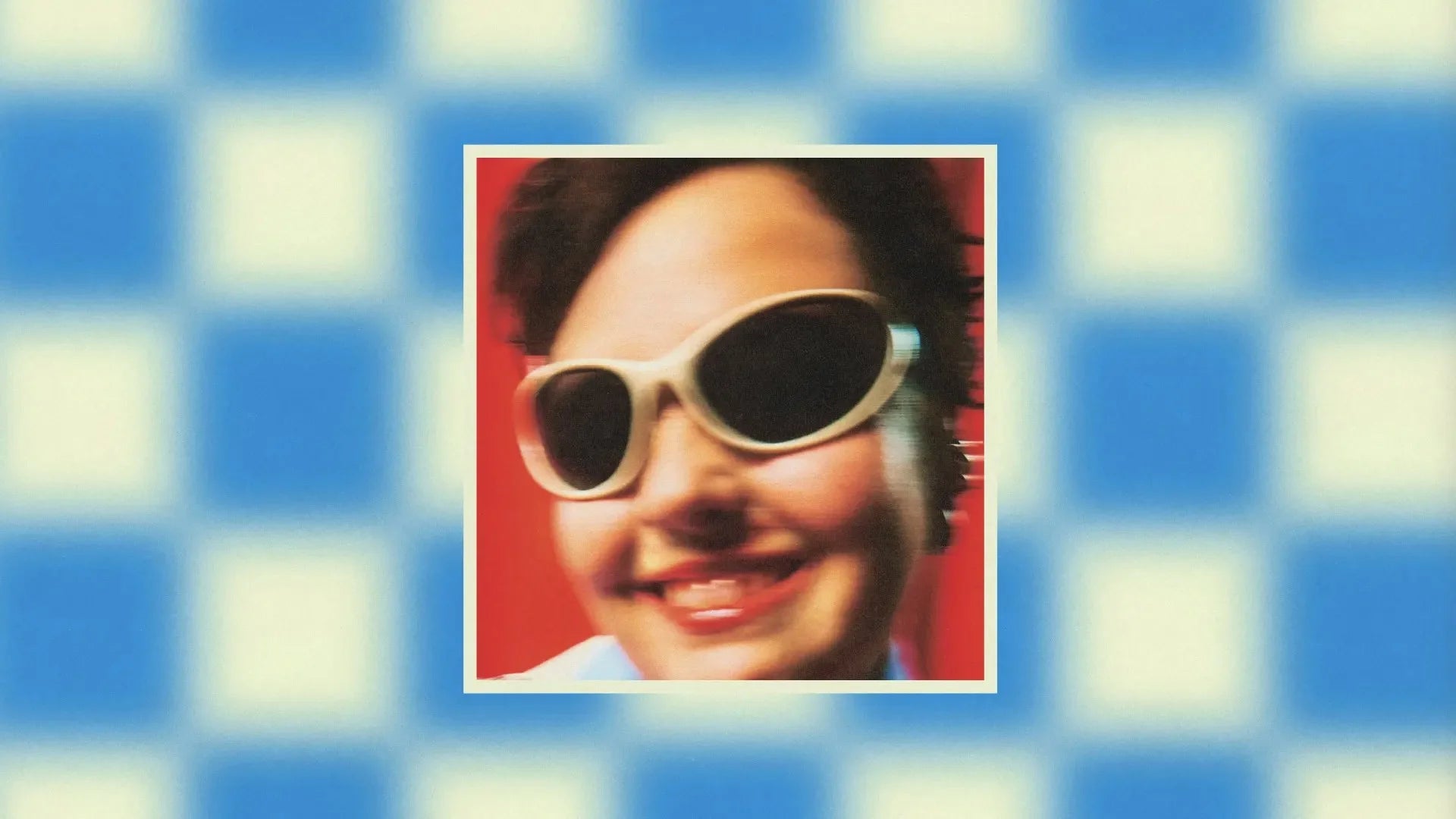 Airs de jeux — pochette d'album, portrait souriant à lunettes blanches sur fond à damier bleu