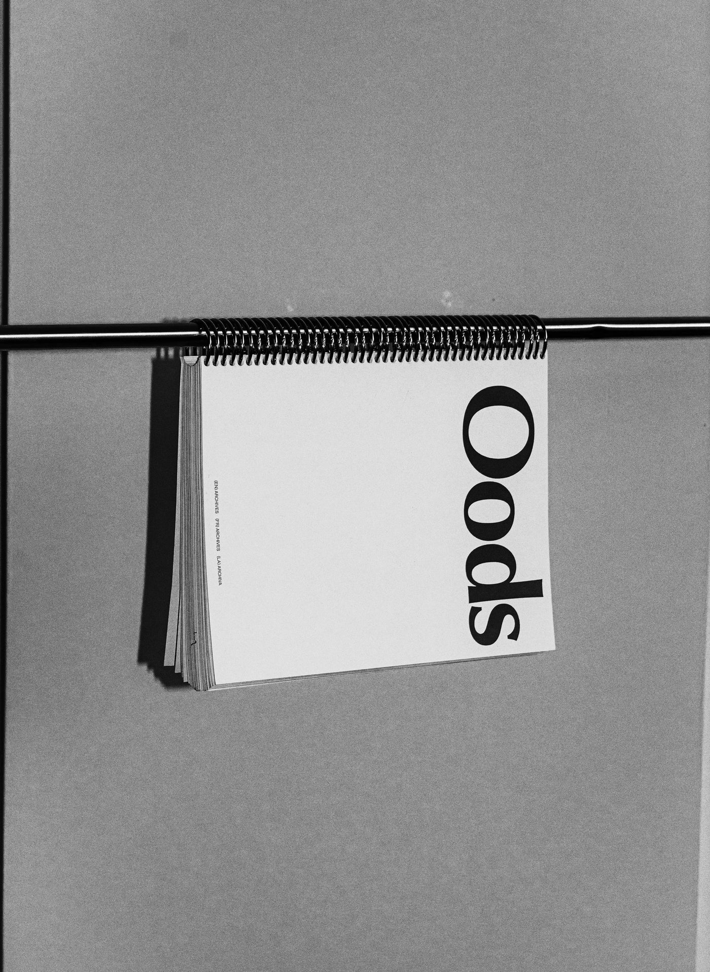 Beyond Time — cahier à spirale du studio OODS suspendu à une tige, couverture blanche