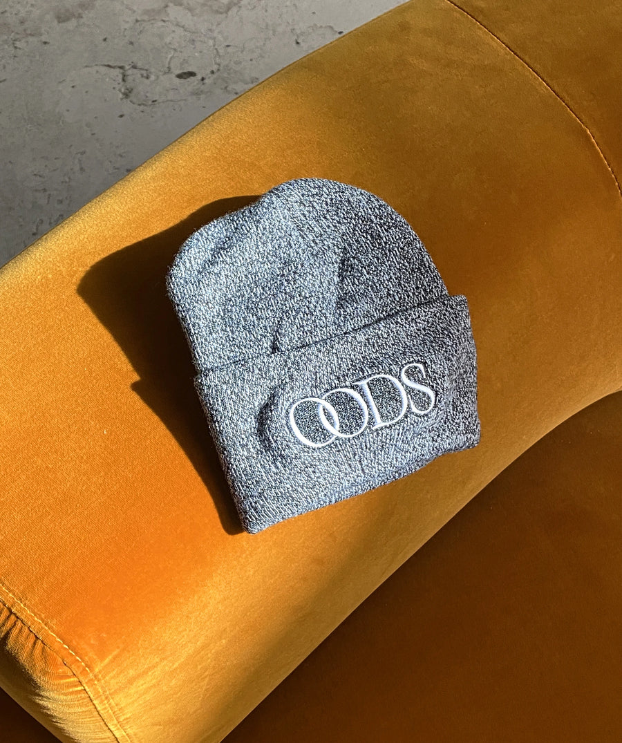 Tuque grise OODS posée sur un tissu jaune