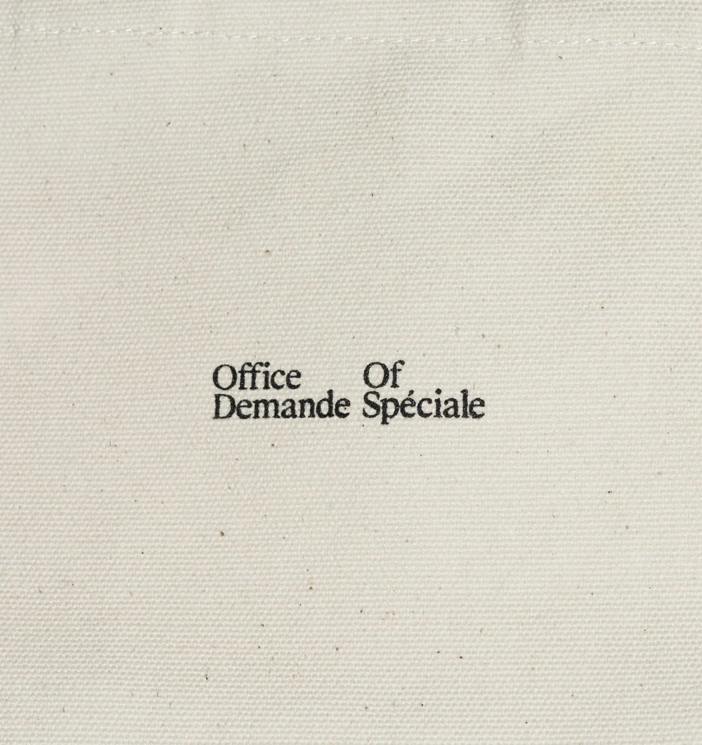 Demande Spéciale — sac tote en toile écrue marqué du wordmark Office Of Demande Spéciale