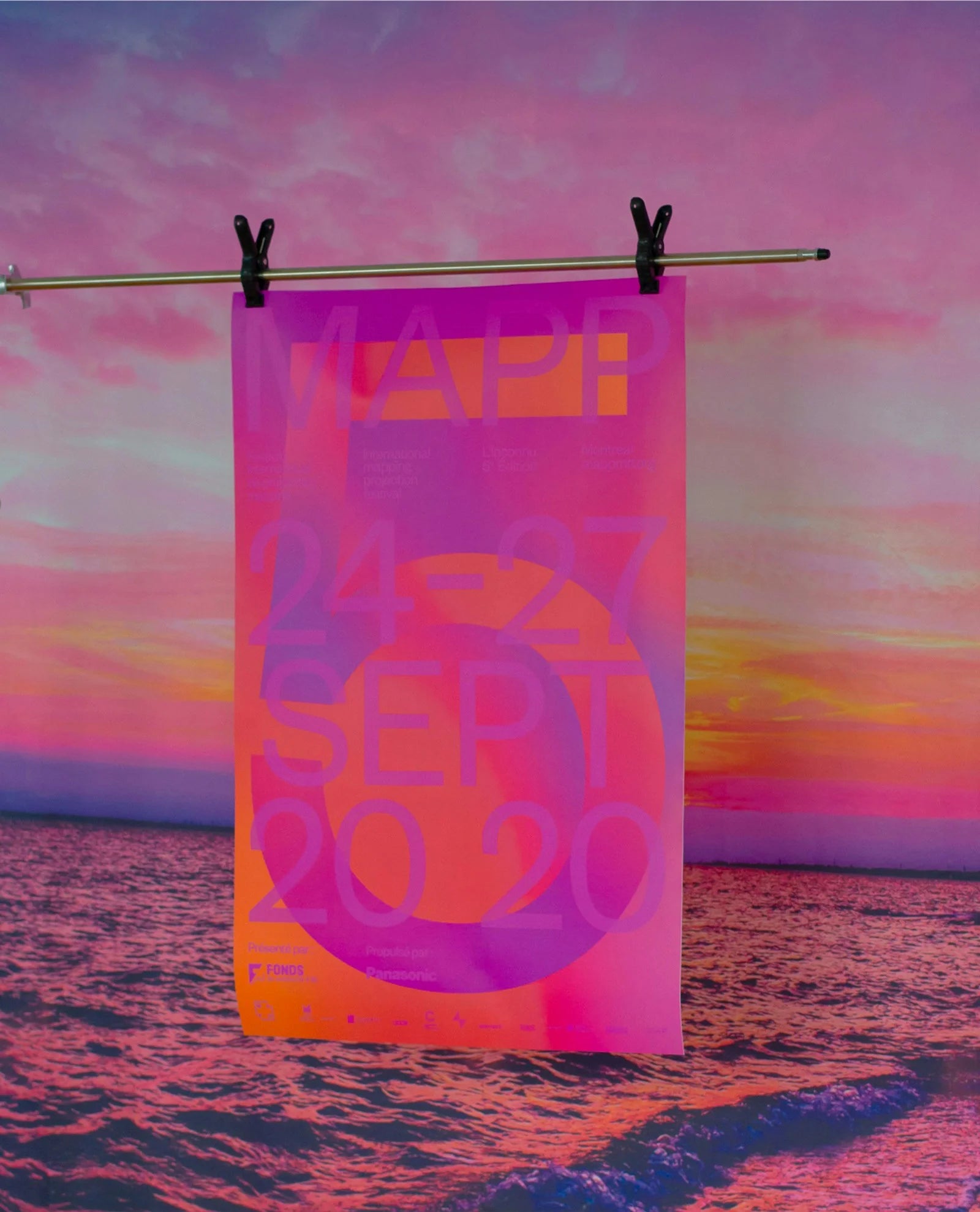 L'inconnu — bannière rose et violet vibrante suspendue devant un coucher de soleil sur la mer