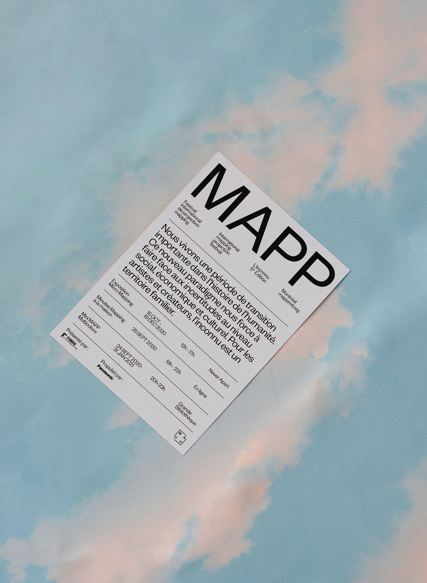 L'inconnu — carton blanc avec wordmark MAPP photographié sur fond de ciel bleu nuageux