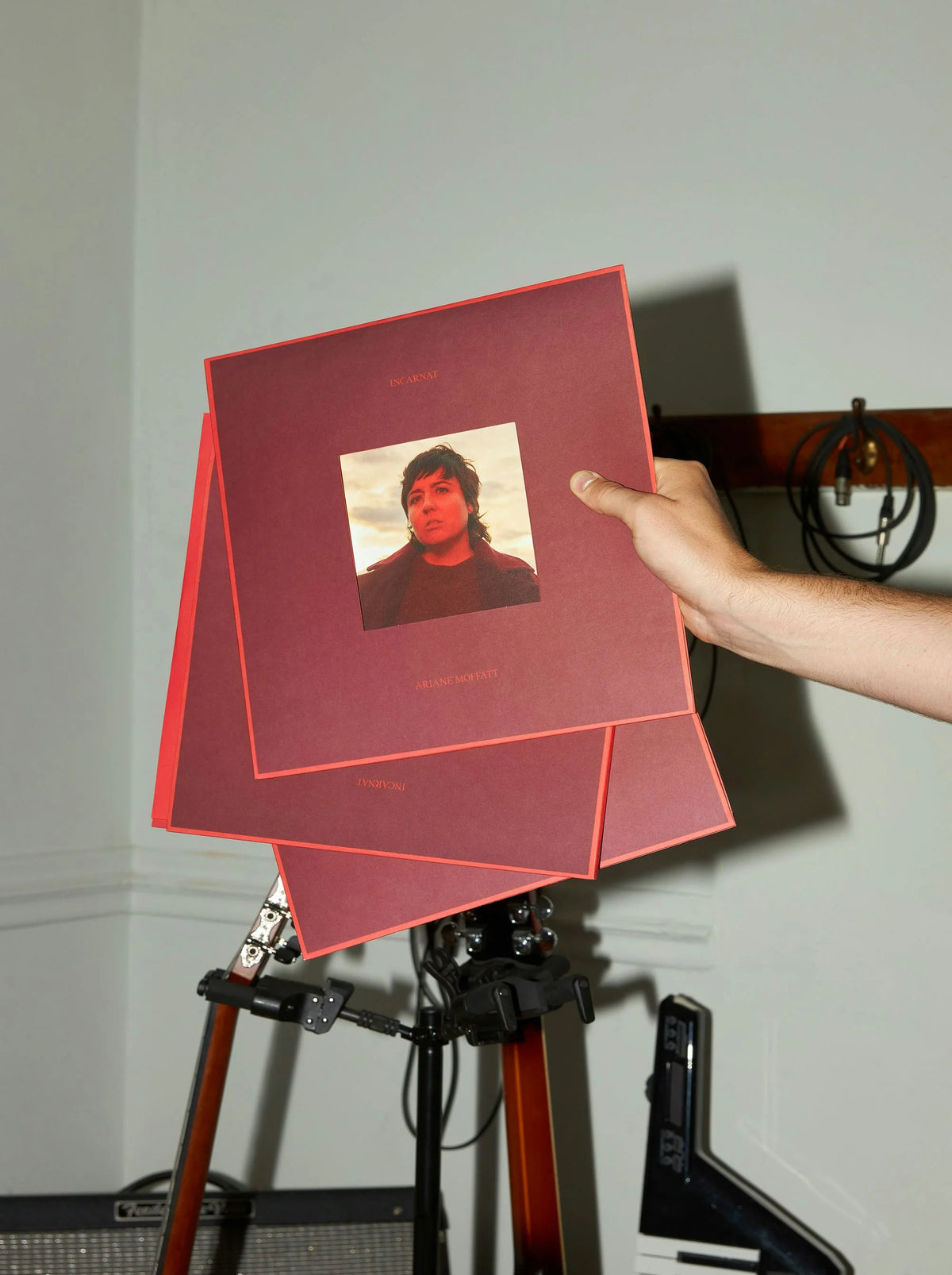 Ariane Moffatt — pochette vinyle rouge d'Ariane Moffatt tenue à la main sur trépied photo