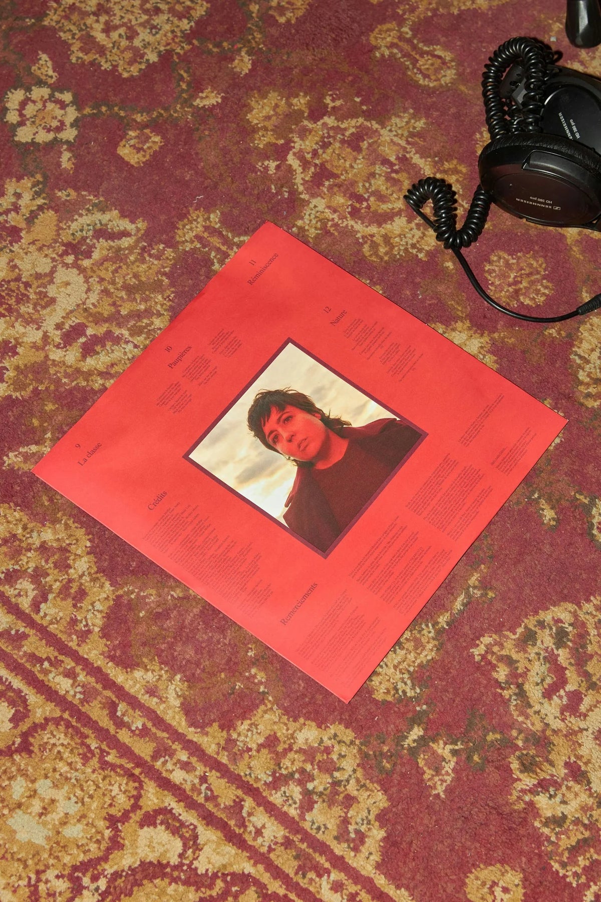 Ariane Moffatt — pochette vinyle rouge d'Ariane Moffatt posée sur un tapis fleuri