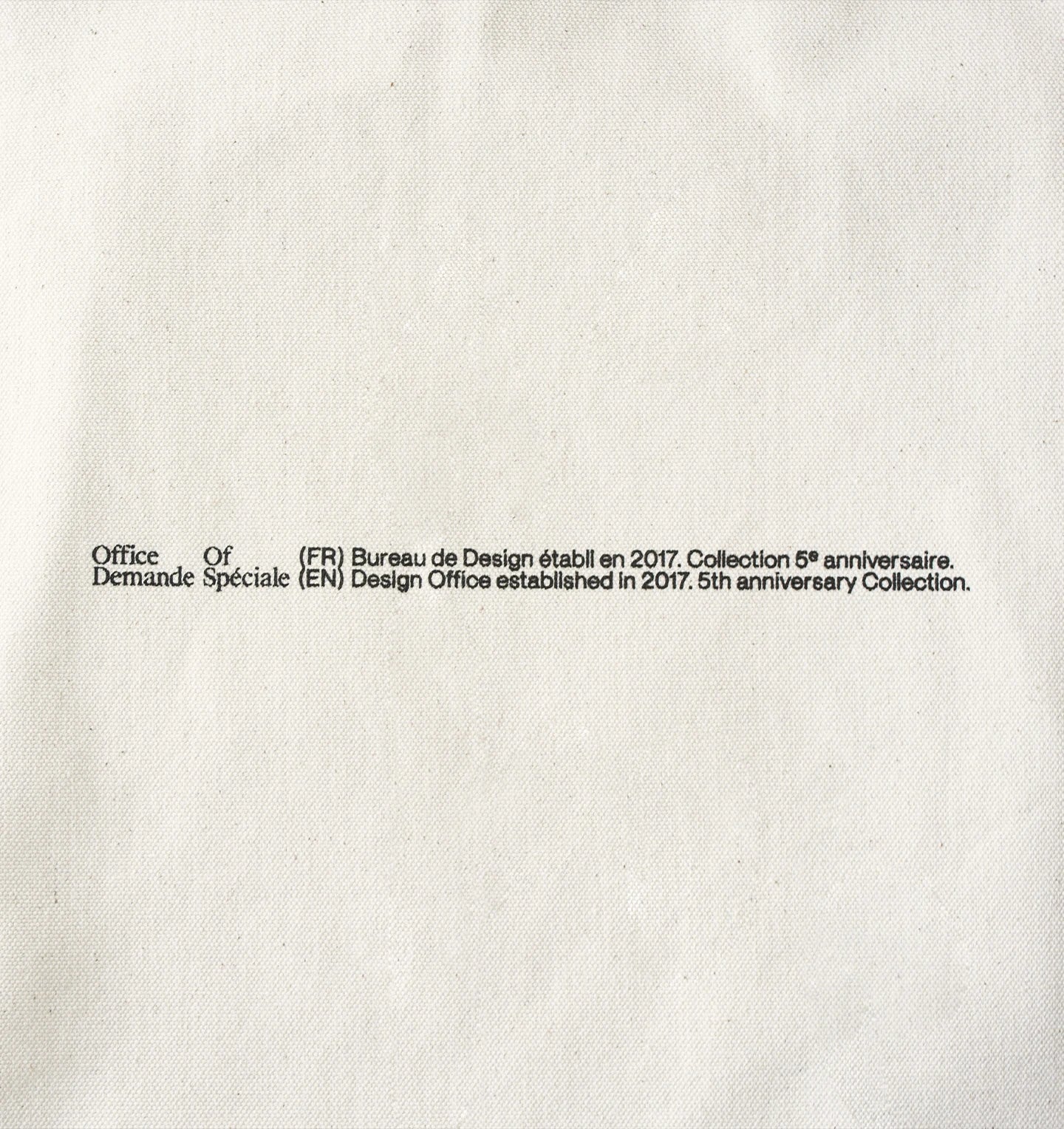 Gros plan du sac écru, fine inscription « Office Of Demande Spéciale »