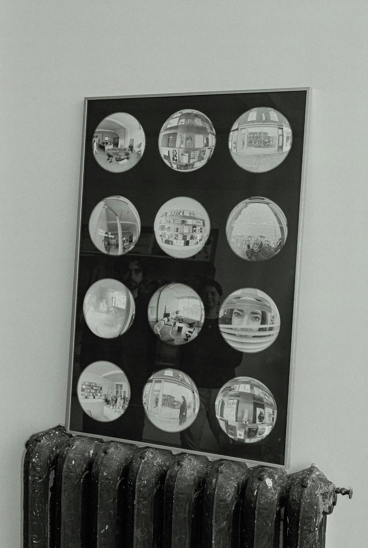 Beyond Time — panneau noir présentant une grille de douze photos circulaires au-dessus d'un radiateur