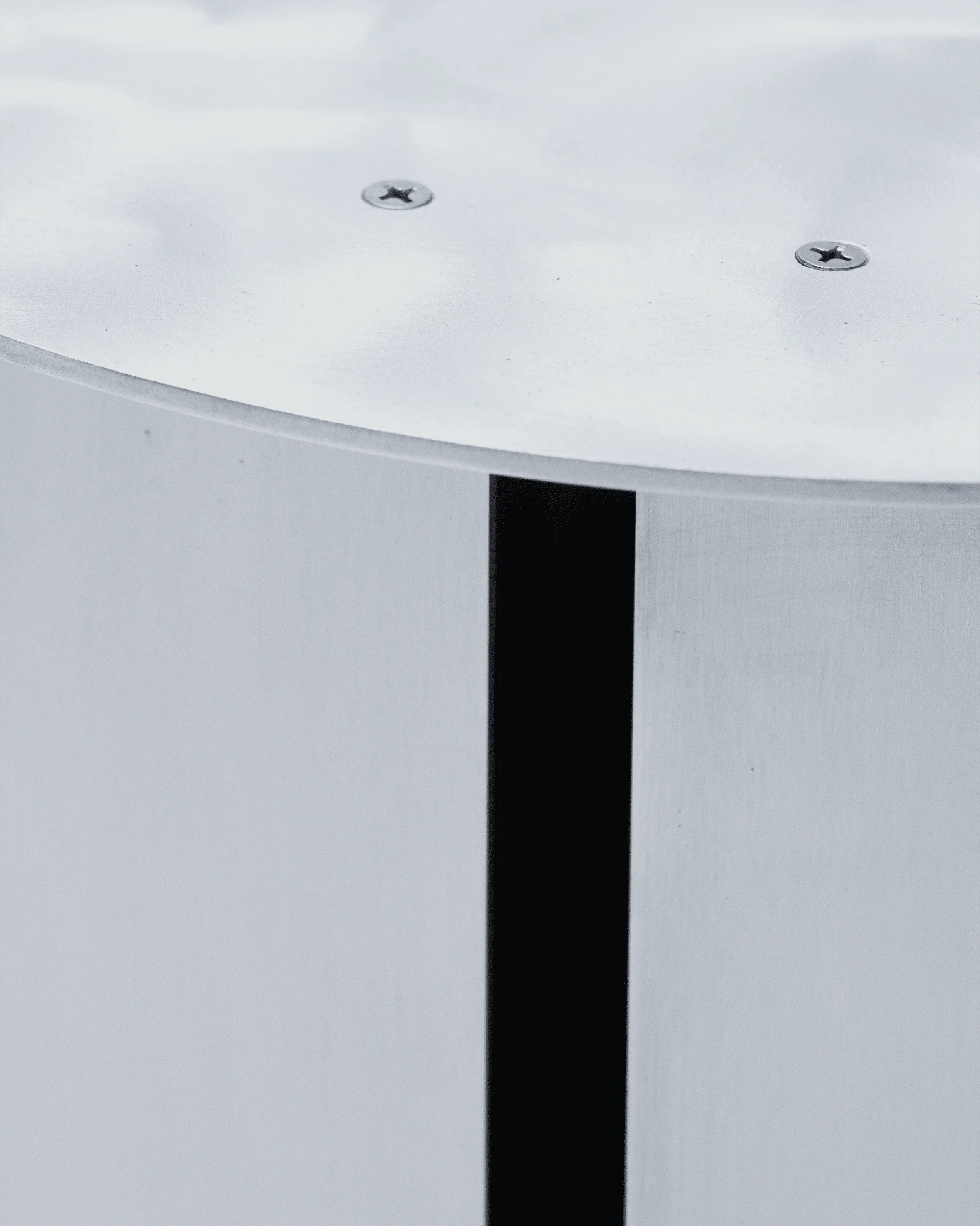 SANGARE — gros plan sur le piètement cylindrique en aluminium d'une table, vis apparentes