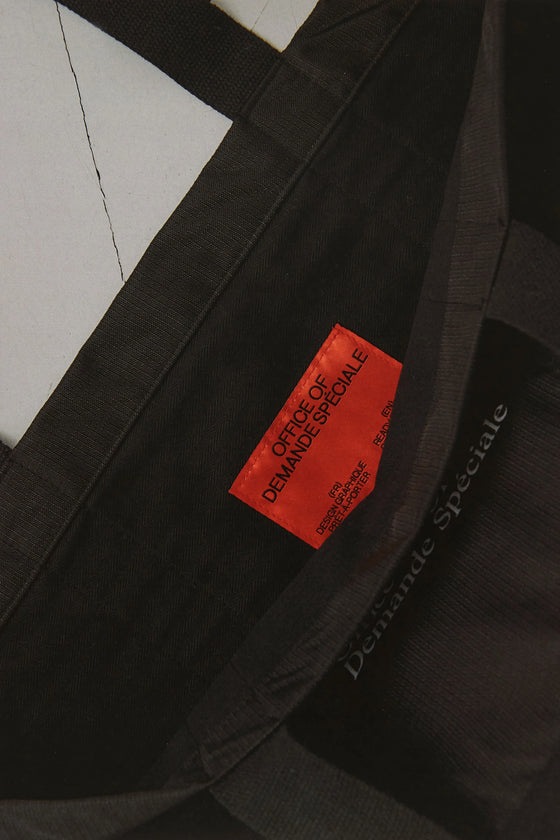 Gros plan de l'étiquette rouge cousue sur le tote bag noir