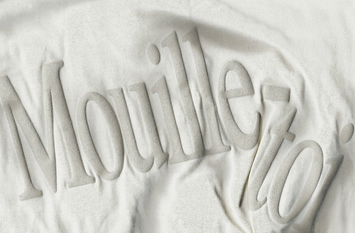 Vazzi — gros plan d'un t-shirt blanc texturé avec lettrage « Mouille-toi » en relief sur le tissu