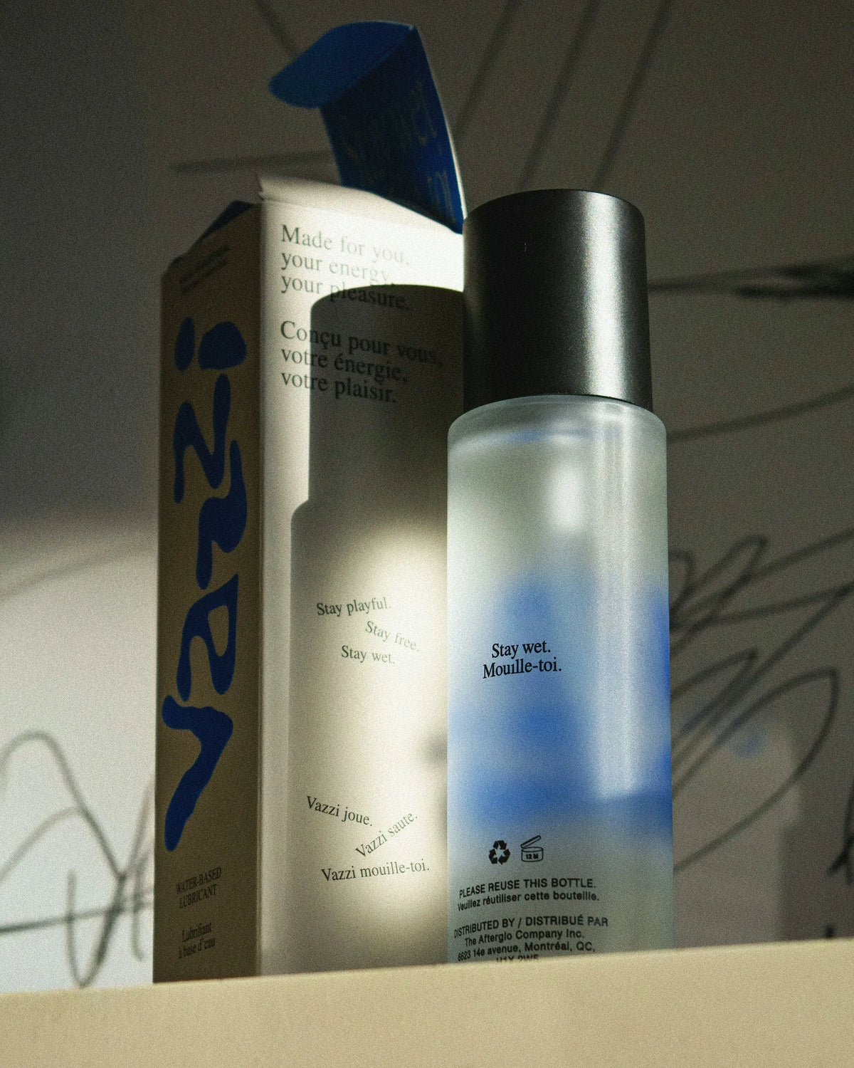 Vazzi — flacon givré à pompe noire et étui imprimé du logo bleu