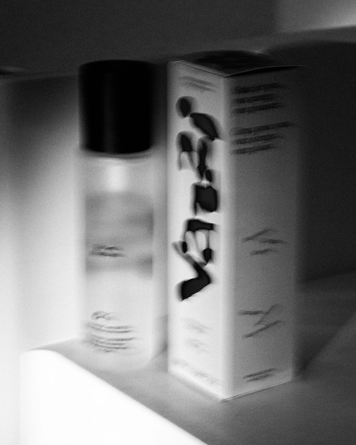Vazzi — flacon et étui sur tablette, image floue en noir et blanc, logo visible