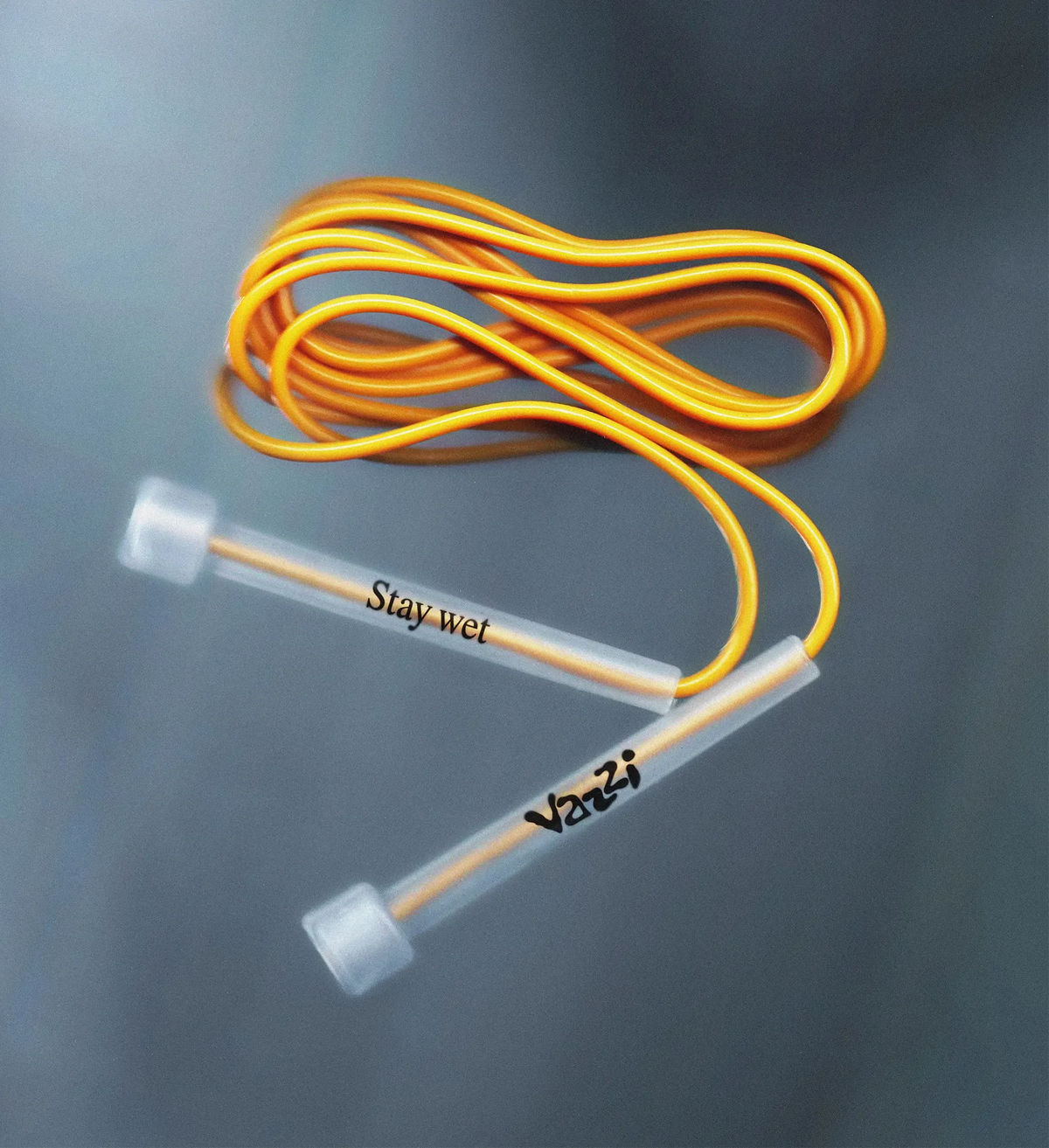 Vazzi — corde à sauter orange aux poignées translucides marquées du logo et « Stay wet »
