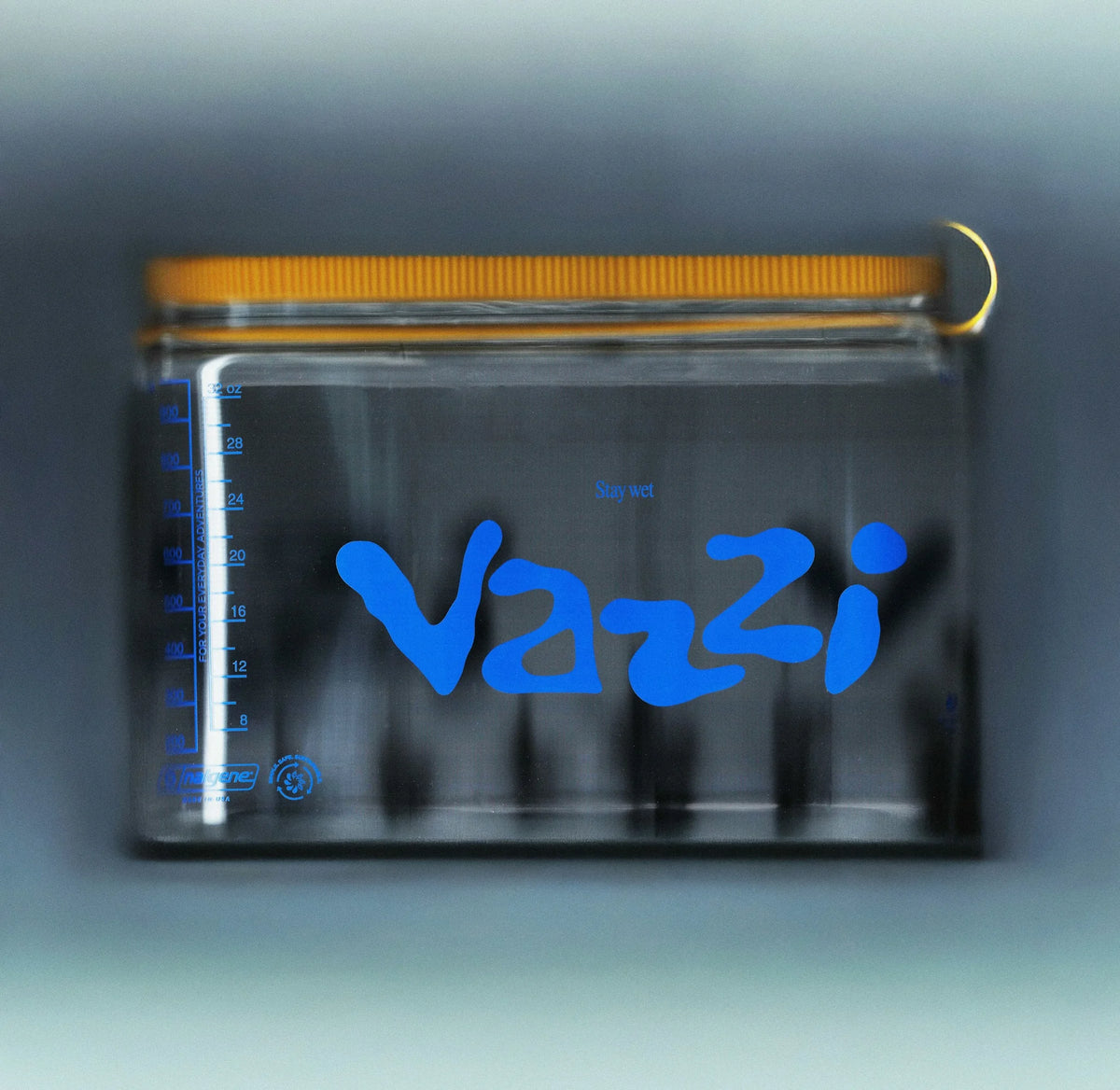 Vazzi — pochette plastique transparente à glissière orange portant le logo bleu