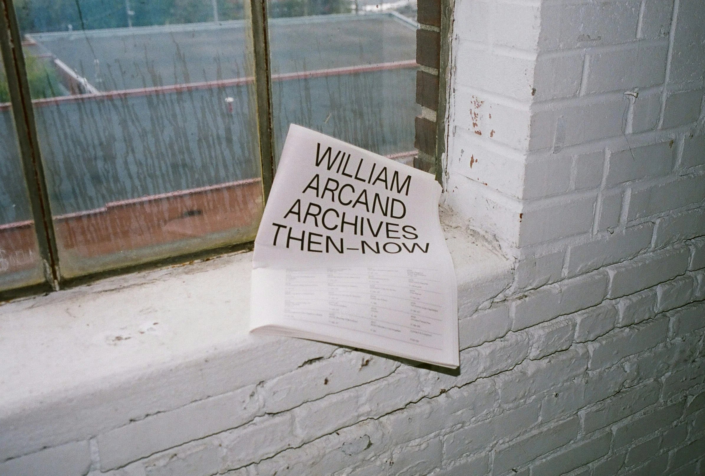 Then-Now — couverture du journal « William Arcand Archives Then-Now » sur rebord de fenêtre