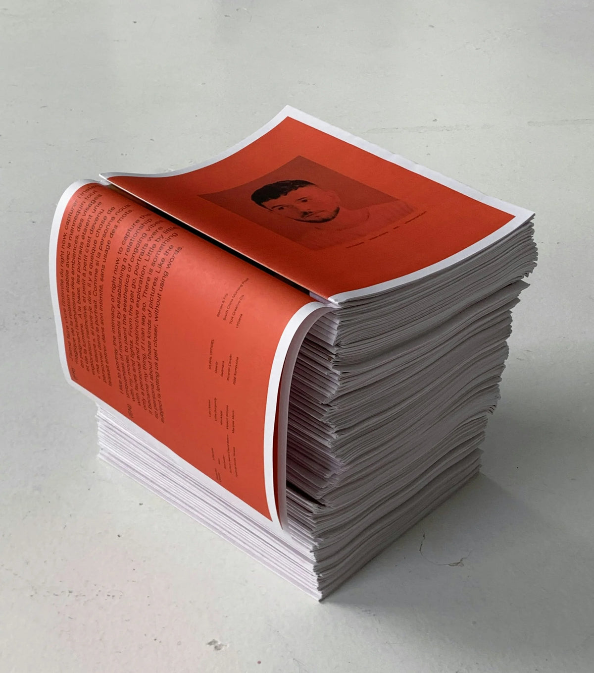 Then-Now — pile du journal ouverte sur une double-page orange vif au texte noir