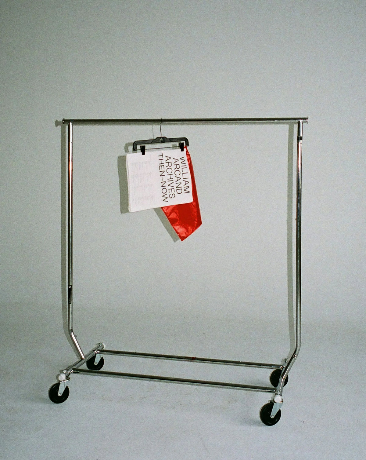 Then-Now — portant à roulettes chromé avec feuillet imprimé et carton orange accrochés à une pince